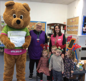 Children, adults and a life sized bear