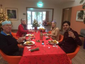 4 people sitting at a red table