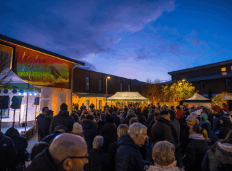 A crowd of people beneath a sign stating 'Light up a Life 2025'