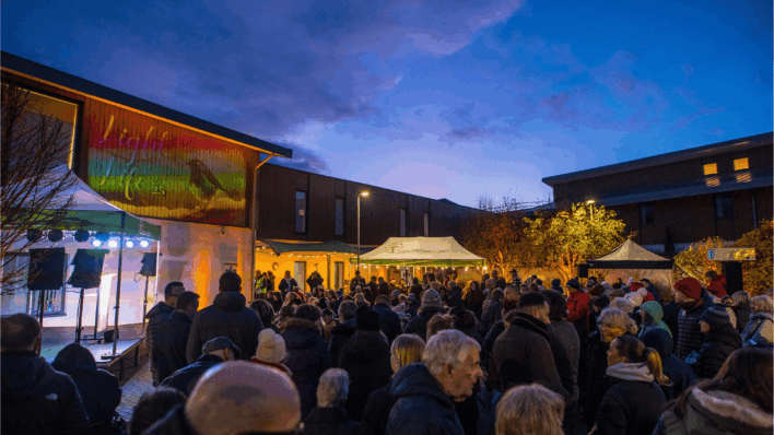 A crowd of people beneath a sign stating 'Light up a Life 2025'
