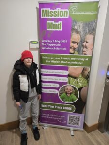 Boy standing near a pull up banner