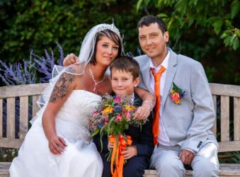 Bride, groom and child on a bench