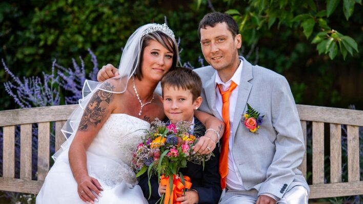 Bride, groom and child on a bench