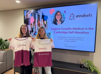 2 females holding tshirts and a screen behind with female photo