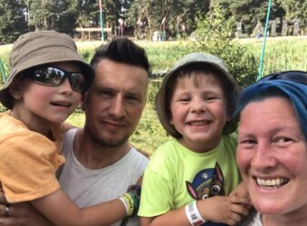 Male and female smiling holding 2 young boys