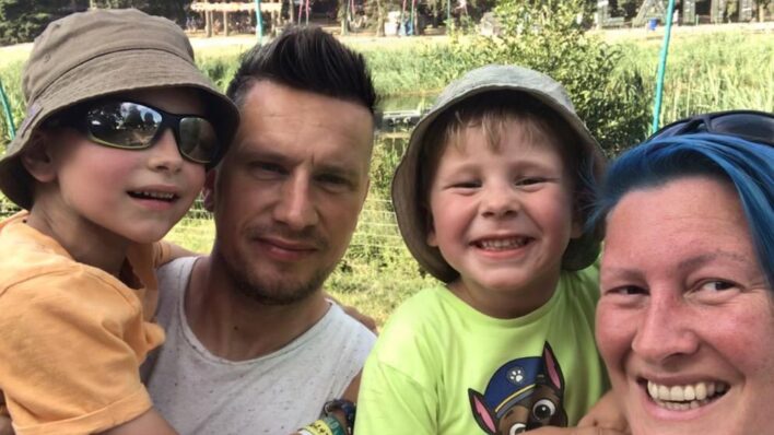 Male and female smiling holding 2 young boys