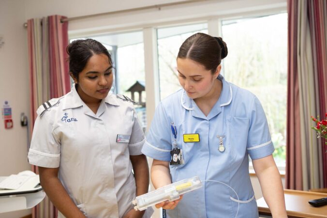 Female nurses caring for patient in bed