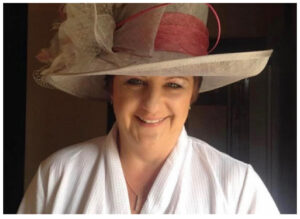 Female wearing a big hat and white dressing gown