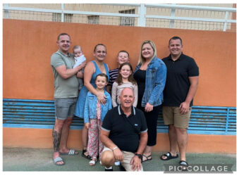 Adults and children in a group smiling at the camera