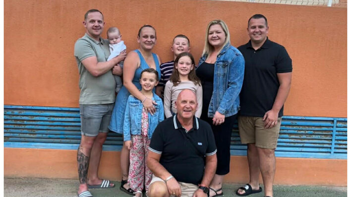 Adults and children in a group smiling at the camera