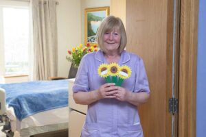 Female nurse holding a cardboard sunflower