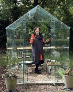 Female standing in a greenhouse