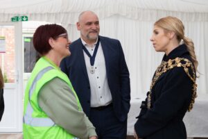 2 females and male talking, female wearing gold decorative chains