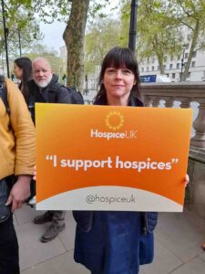 Female holding orange sign - I support hospices