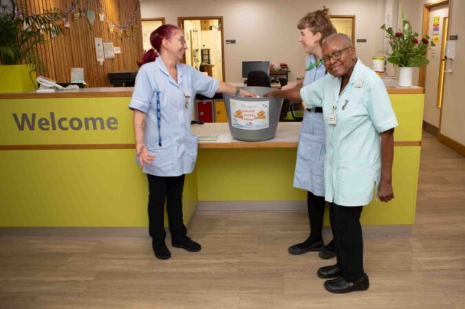 3 nurses with a big grey tub