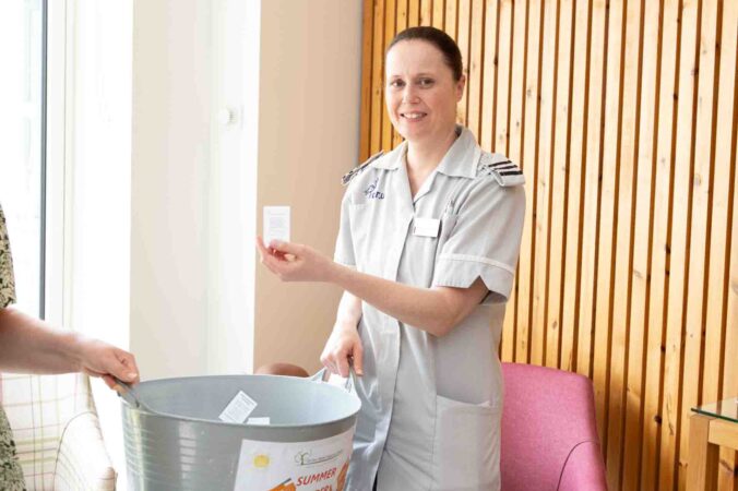 Nurse with a big grey tub and ticket