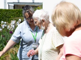 Female nurse with 2 females in the garden