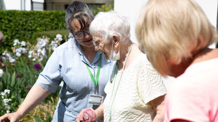Female nurse with 2 females in the garden