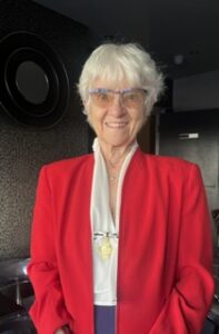 Female wearing red jacket and medal
