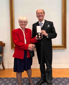 Female and male holding a medal