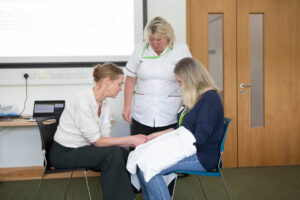 Three females massaging hands