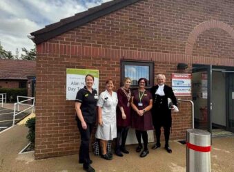Nurses and male and female outside a building