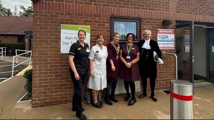 Nurses and male and female outside a building