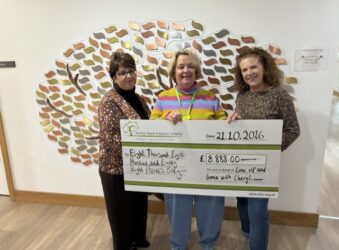3 females holding a large cheque