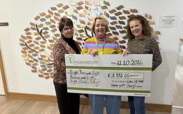 3 females holding a large cheque