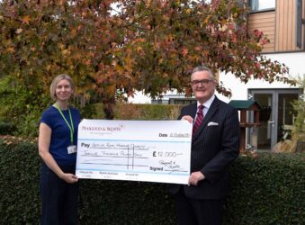 Female and male holding a large cheque