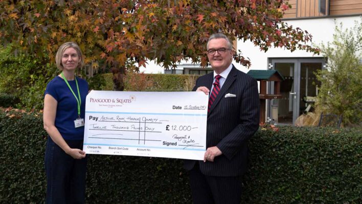 Female and male holding a large cheque